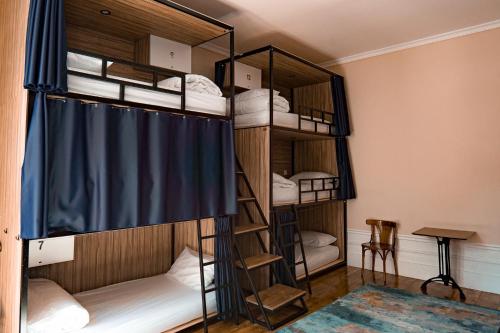 Zimmer mit Etagenbetten und einem blauen Vorhang in der Unterkunft Rosalma Hostel in Porto