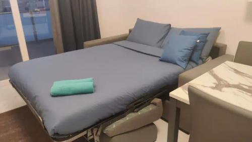 a bed with blue pillows and a green object on it at Blu-M Central in Qormi