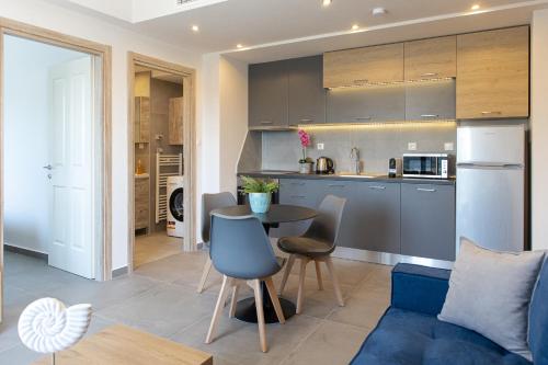 a kitchen and living room with a table and a couch at Anais Apartments in Korinós