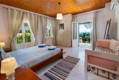 a bedroom with a bed and a table and a couch at Angelina Villa by PaxosRetreats in Lákka