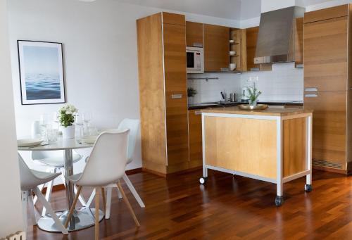 a kitchen and dining room with a table and chairs at 2ndhomes Luxury 1BR Kamppi Center Apartment with Sauna and Big Terrace in Helsinki