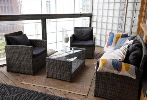 2ndhomes Luxury 1BR Kamppi Center Apartment with Sauna and Big Terrace في هلسنكي: غرفة معيشة مع كراسي الخوص وطاولة