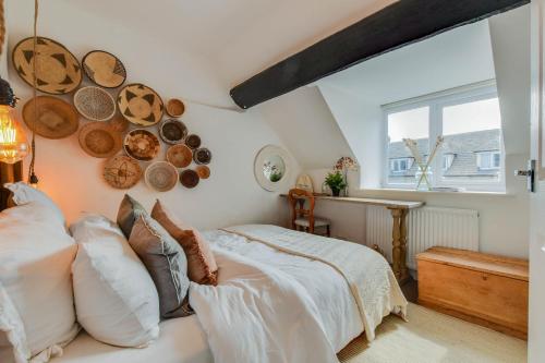 a bedroom with a bed and some plates on the wall at The Nook, Newly Available Relaxed 2 bed, Cotswolds in South Cerney