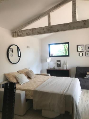 una camera da letto con un letto grande e una finestra di LA BRINDILLE Petit mas provencal meublé de tourisme 3 étoiles 2-3 personnes 1 piece 30 m2 tout confort lisière foret jardin Jacuzzi Piscine a Saint-Paul-en-Forêt