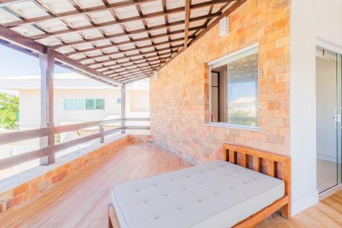 a room with a bench on a brick wall at GB03 Maravilhosa Casa 5 Suítes a 200m da Praia in Guarajuba