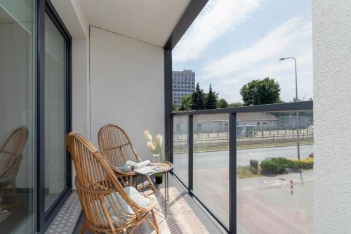 a balcony with two chairs and a view of a street at Apartment with Balcony & Parking Mogilska by Renters Prestige in Krakow