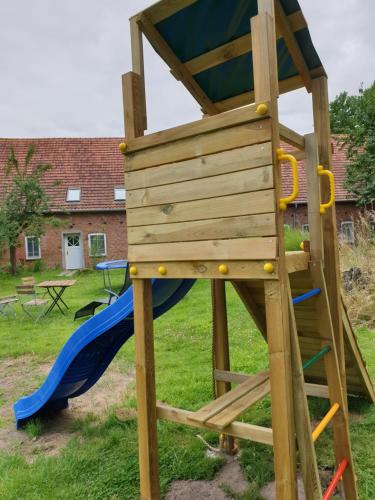 a wooden play tower with a slide at Adelheidshof in Magelsen