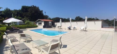 a patio with chairs and a swimming pool with umbrellas at Zia Bi Bed and Breakfast in Naples