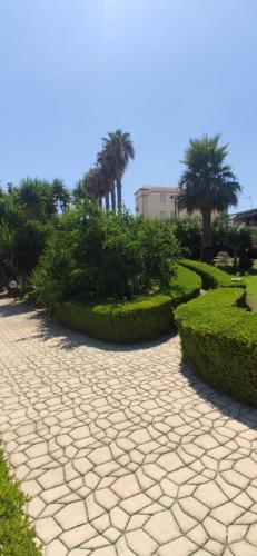 a stone walkway in a park with palm trees and bushes at Zia Bi Bed and Breakfast in Naples