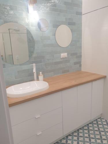 a bathroom with a sink and a mirror at Apartament Pod Żaglami in Zegrze Południowe