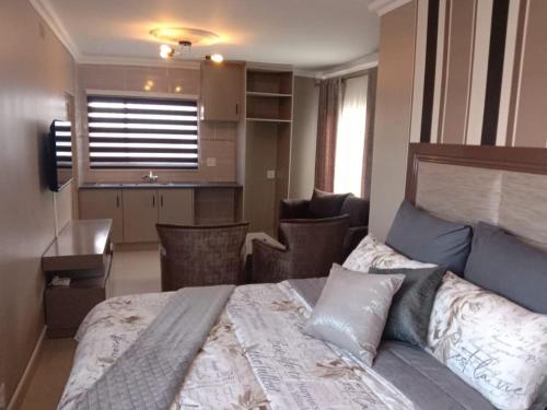1 Schlafzimmer mit einem großen Bett und einer Küche in der Unterkunft Lemao Properties/guest house in Johannesburg