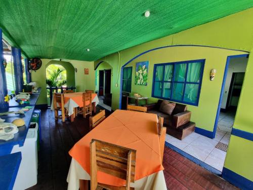 comedor con mesa y sillas de color naranja en Cabinas Tortuguero Natural en Tortuguero