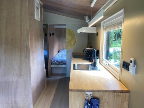ein winziges Haus mit einem Waschbecken und einem Schlafzimmer in der Unterkunft Chalet "naast de Schoppe" in Aalten