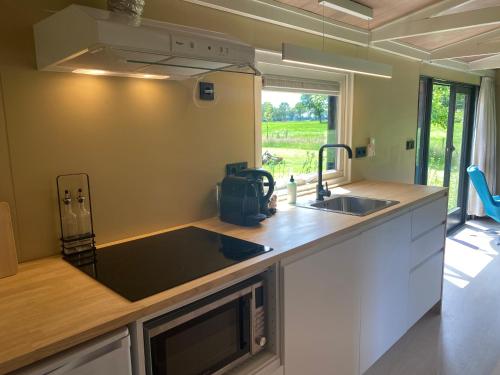 eine Küche mit einer Spüle und einer Arbeitsplatte in der Unterkunft Chalet "naast de Schoppe" in Aalten