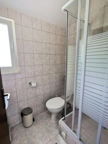 a bathroom with a toilet and a glass shower at Apartman Dubravka 1 in Orebić