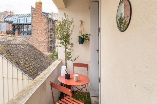 - une petite table rouge sur le balcon d'une maison dans l'établissement MELI MELAINE - Appartement 3 chambres avec balcon centre historique, à Rennes