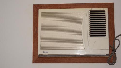 a white air conditioner in a wooden frame on a wall at Casa Agradável com piscina. in Miguel Pereira