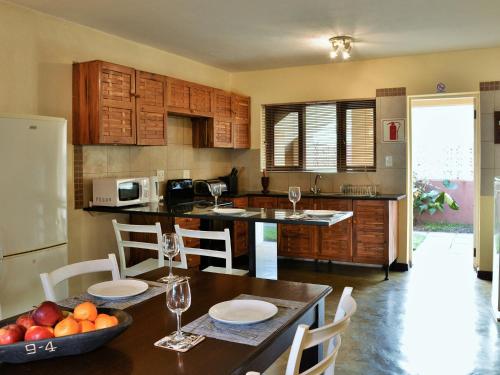 a kitchen with a table with a bowl of fruit on it at Bilene Lodge by Dream Resorts in Vila Praia Do Bilene