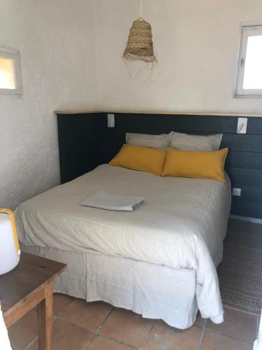 une chambre avec un lit avec un ordinateur portable dessus dans l'établissement Cabanon du berger, à Saignon