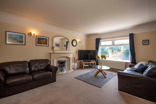 uma sala de estar com dois sofás de couro e uma lareira em Rose Cottage em Chester
