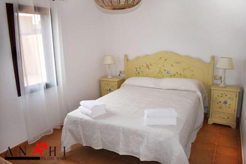 a bedroom with a bed with two night stands and a window at Anahi Home Corralejo - Villa Cardon 12 in La Oliva