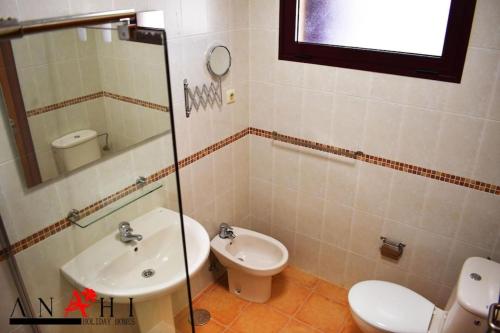 a bathroom with a toilet and a sink at Anahi Home Corralejo - Villa Cardon 12 in La Oliva