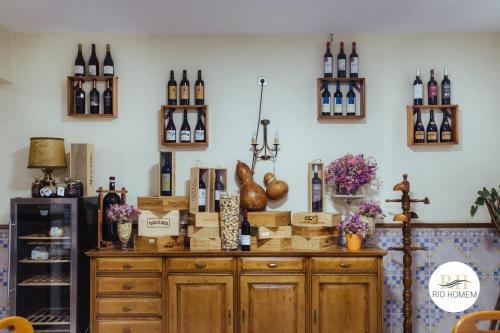a room with bottles of wine on a wall at Rio Homem in Terras de Bouro