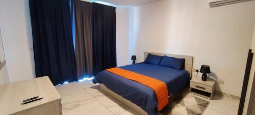 a bedroom with a bed with blue and orange at Blu-M Central in Qormi
