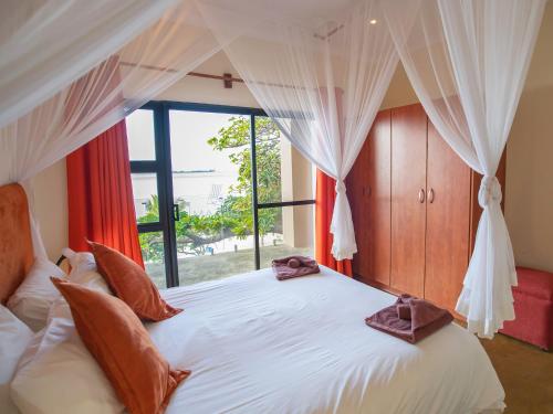 a bedroom with a large bed with a window at Bilene Lodge by Dream Resorts in Vila Praia Do Bilene