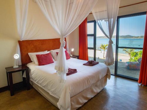 a bedroom with a bed with a view of the ocean at Bilene Lodge by Dream Resorts in Vila Praia Do Bilene