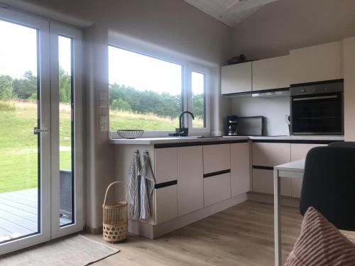 eine Küche mit weißen Schränken und einem großen Fenster in der Unterkunft TINY LIEBE Ostsee Ostsee- bei Wismar in Neuburg