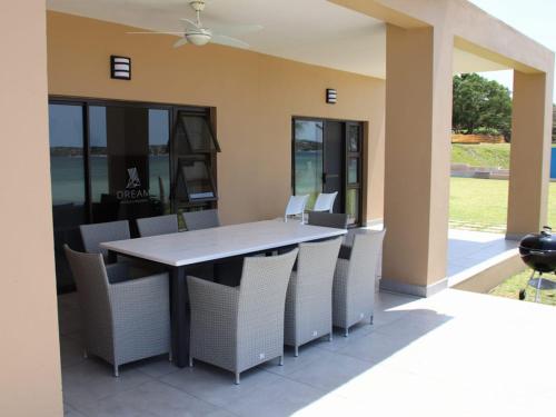 a dining table and chairs on a patio at Bilene Lodge by Dream Resorts in Vila Praia Do Bilene