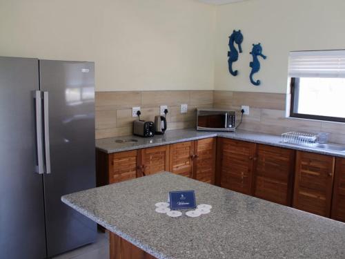 a kitchen with a stainless steel refrigerator and a counter at Bilene Lodge by Dream Resorts in Vila Praia Do Bilene
