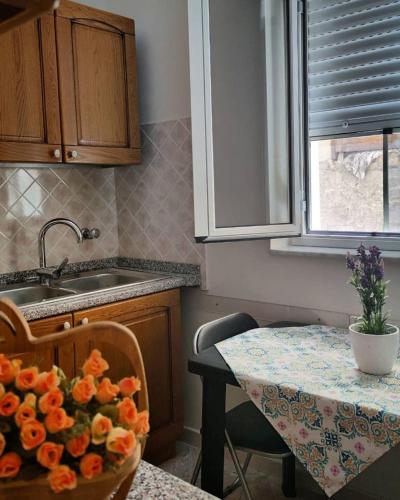 una cocina con una mesa con un tazón de flores. en La Margherita - Casa vacanze, en Montallegro