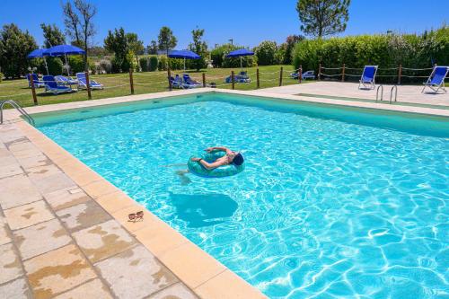 a person is swimming in a swimming pool at Residenza Principina in Principina Terra