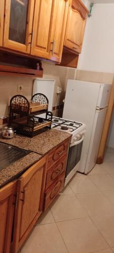 eine Küche mit einem Herd und einem weißen Kühlschrank in der Unterkunft Appartement a louer pour les vacances in Tangier
