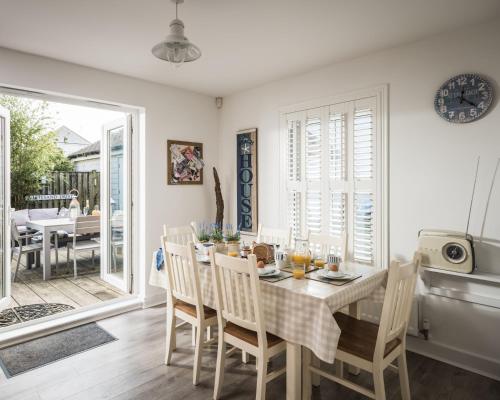 a kitchen and dining room with a table and chairs at Camber Beach House in Camber