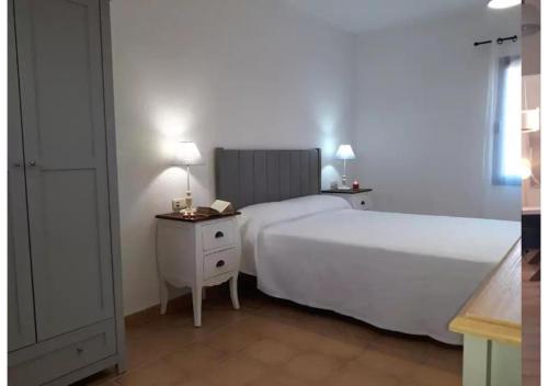 1 dormitorio con 1 cama blanca grande y 2 mesitas de noche en Anahi Homes Corralejo - Villa Codeso 5, en La Oliva