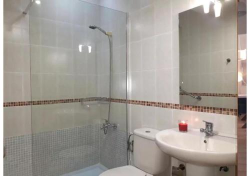 y baño con aseo, lavabo y ducha. en Anahi Homes Corralejo - Villa Codeso 5, en La Oliva