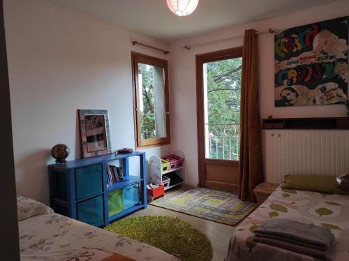 um quarto com uma cama e um armário azul e uma janela em Tressan:La Calade, maison d'artiste em Tressan