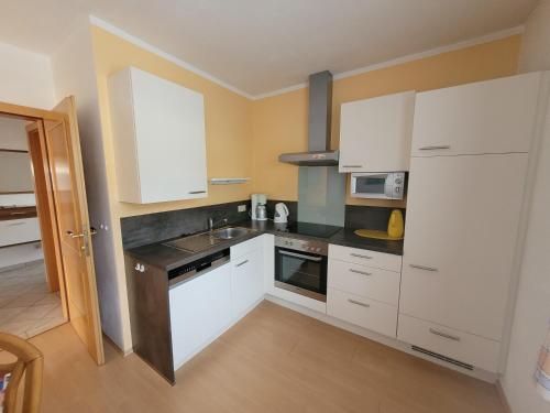 a kitchen with white cabinets and a sink at Appartement Pölzl Öblarn Region Schladming Dachstein in Öblarn