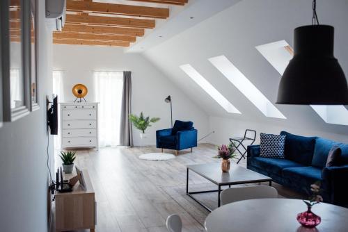 a living room with a blue couch and a table at Style Inn Apartmanok in Veszprém