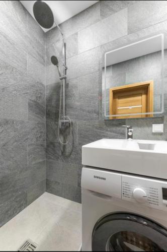 a bathroom with a washing machine and a sink at 16 Airport Apartment in Vilnius