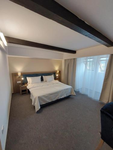 a bedroom with a large white bed and a table at New Wolf in Bran