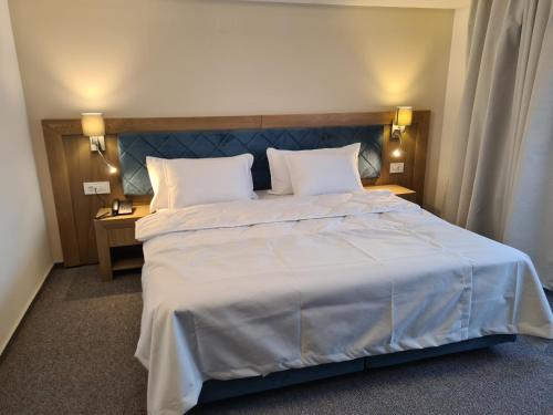 a bedroom with a large white bed with two pillows at New Wolf in Bran