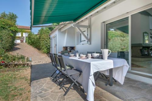 une table avec un tissu de table blanc sur une terrasse dans l'établissement Maison pour 8 personnes à 300 m de la plage, à Pornic