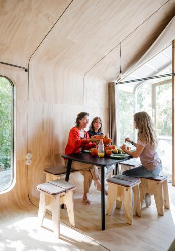 three women sitting at a table in a tiny house at les Cabanes d'Ostende in Ostend