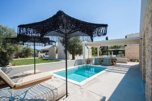 odkryty basen z parasolem i basen w obiekcie Utopia Eco Retreat w mieście Skiatos