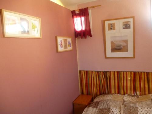 ル・バルカレスにあるLes Bastides du Capのベッドルーム1室(ベッド1台付)が備わります。壁に2枚の写真が飾られています。