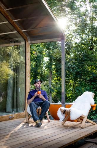 a man sitting on the back porch of a house at les Cabanes d'Ostende in Ostend